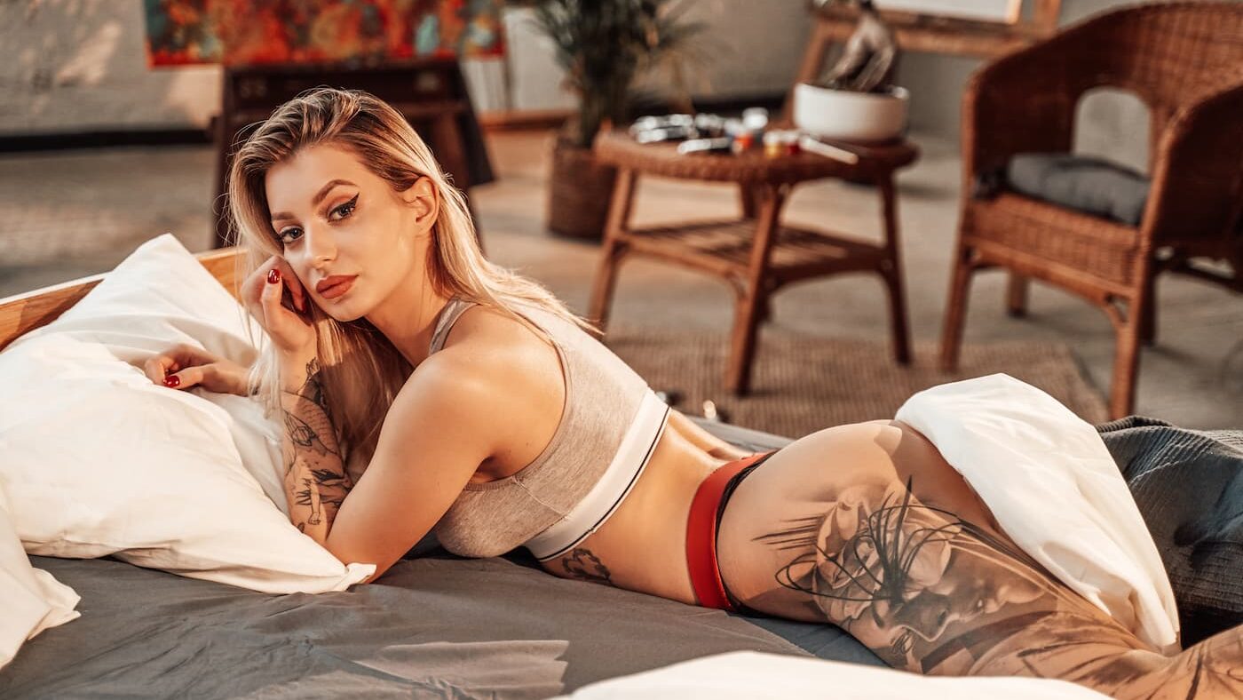 Sexy blonde woman with tattoo on leg.